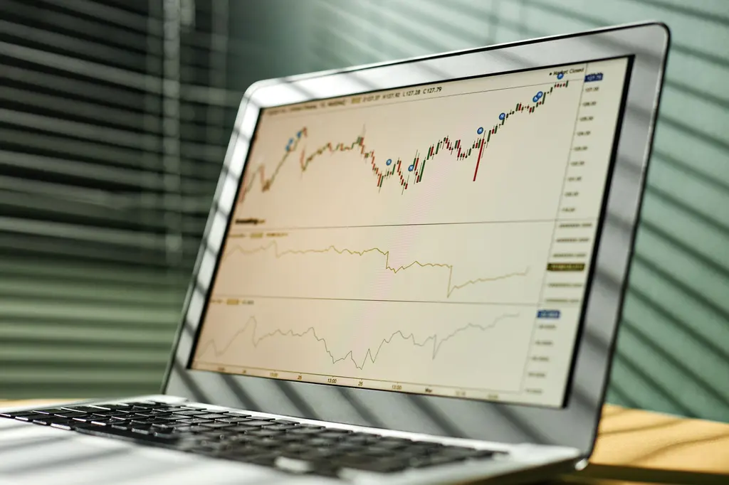Portátil com dados e gráficos do mercado bolsista num escritório